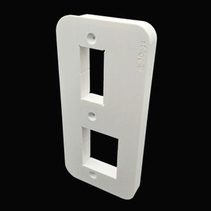 May include: A white, rectangular wall plate with two openings, one rectangular and one square. The plate has rounded edges and small screw holes. The text "@3dligs" is printed on the side.