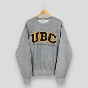 May include: A set of three ceramic mugs with a speckled, matte finish. The mugs are in shades of cream, light gray, and dark gray. Each mug has a simple, modern design and a rounded handle.