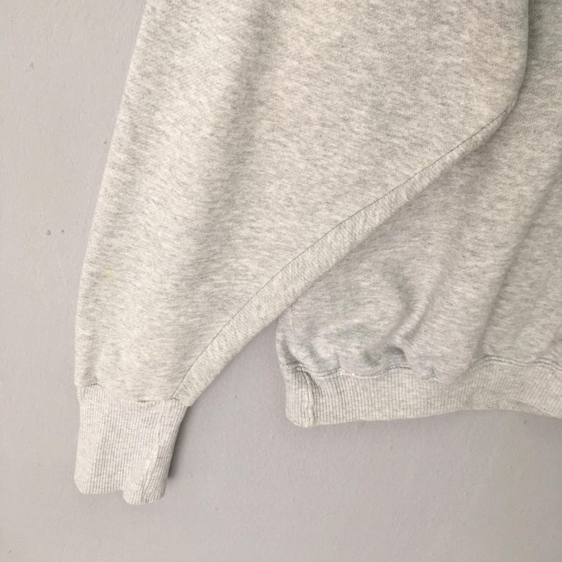 Puede incluir: Una sudadera de color gris jaspeado claro que presenta mangas largas con pu&ntilde;os acanalados y un dobladillo acanalado. La prenda est&aacute; confeccionada con un tejido suave y texturizado con un dise&ntilde;o de cuello redondo cl&aacute;sico y funcional.