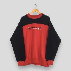 Puede incluir: Una sudadera roja y negra con el texto "Earnhardt Jr. 8" en el pecho. La sudadera tiene cuello redondo y mangas largas. La parte superior y las mangas son negras, mientras que el cuerpo es rojo.