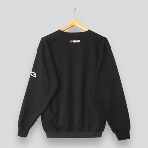 May include: Black sweatshirt with the NASCAR logo in the upper back and the number 3 on the left sleeve. The sweatshirt is hanging on a wooden hanger against a light gray background.