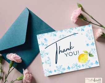 May include: A white thank you card with a blue floral pattern and a lemon illustration. The card says "Thank You!" in navy blue lettering.
