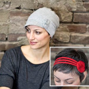 May include: A light gray beanie-style hat with a small flower accent. The hat is made of a soft fabric and is worn by a person. A close-up shows a red headband with a fabric flower.