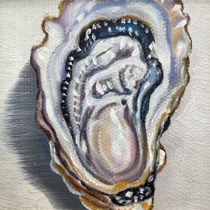 May include: Oil painting of an oyster shell in a gold frame. The shell is painted with shades of white, blue, purple, and brown. The oyster's interior has a pearlescent sheen, and the frame has a detailed, ornate design.