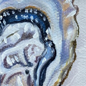 May include: Close-up of an abstract oil painting featuring an oyster shell. The artwork uses a palette of white, blue, brown, and gold. The brushstrokes are thick and textured, creating a sense of depth and movement. The painting has a natural, organic theme.