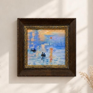 May include: A square oil painting depicting a harbor scene at sunrise with blue and orange hues, featuring small boats on water. The artwork is encased in a dark brown wooden frame with an inner gold-toned decorative border with carved details.