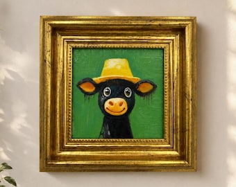 Könnte beinhalten: Ein Ölgemälde einer schwarzen Kuh mit einem gelben Hut, zentriert vor einem einfarbigen grünen Hintergrund. Das Kunstwerk befindet sich in einem dicken, verzierten, goldfarbenen Metallrahmen mit mehrstufigem Profil und einer Perlenkante.