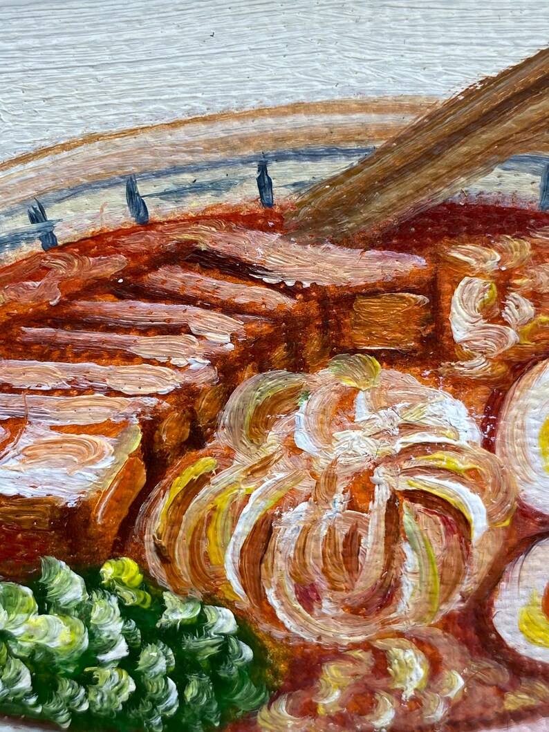 May include: An oil painting depicting a bowl of ramen with thick slices of brown pork, a soft-boiled egg with a yellow yolk, and a cluster of green scallions. The broth is a deep reddish-orange color, and a wooden spoon rests inside the bowl.