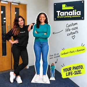 May include: A custom life-size cardboard, plastic or aluminium cutout of a person wearing a teal long-sleeved shirt and blue jeans, standing with arms crossed. A smaller 30 cm mini version is included, with text reading Custom life-size cutouts.
