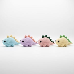 Puede incluir: Cuatro juguetes de dinosaurios de ganchillo en colores pastel: azul claro, lavanda, rosa y amarillo. Cada dinosaurio tiene espinas y cola de color contrastante, con ojos negros. Estos juguetes de peluche hechos a mano son ideales para niños.