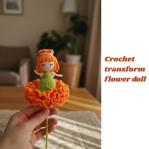May include: A handmade crochet flower doll with an orange flower skirt, green bodice, and orange hair. The doll has a pearl crown and is held by a hand. The text "Crochet transform flower doll" is on the right.