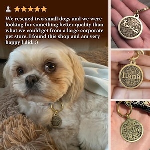 May include: A round, gold-toned metal pet identification tag featuring an intricate, embossed floral pattern and a central horizontal bar engraved with a name. The tag includes a circular split ring for attachment to a collar or harness.