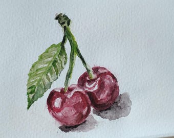 Könnte beinhalten: Aquarellmalerei von zwei reifen Kirschen mit grünen Stielen und einem Blatt. Die Kirschen sind tiefrot mit Glanzlichtern, und das Blatt ist grün mit detaillierten Adern. Das Gemälde befindet sich auf weißem Papier.