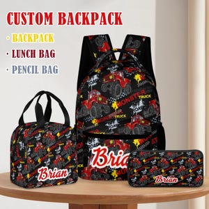 May include: A custom backpack set featuring a backpack, lunch bag, and pencil bag. The set has a black background with a red monster truck design and the name "Brian" in a white and red font. The text "CUSTOM BACKPACK" is at the top.