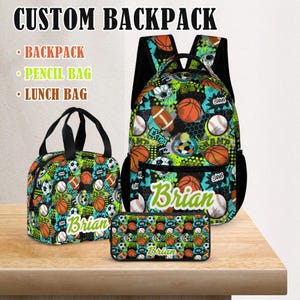 Puede incluir: Un conjunto de mochila personalizado con mochila, estuche y bolsa de almuerzo. El conjunto tiene un patrón deportivo colorido con balones de baloncesto, fútbol y béisbol. El nombre "Brian" está impreso en cada bolsa.