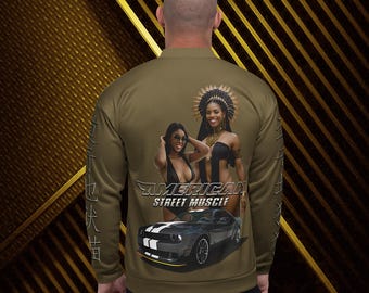 May include: Olive green bomber jacket featuring a graphic of two women and a car, with the text "AMERICAN STREET MUSCLE". The jacket has a ribbed collar, cuffs, and hem, and a zipper closure. The design is on the back of the jacket.