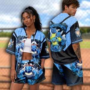 May include: A short-sleeved button-down shirt and matching shorts set featuring a blue and black graphic print of various water-type creatures and handheld gaming consoles. The design includes the text I CHOOSE WATER and blue geometric patterns.