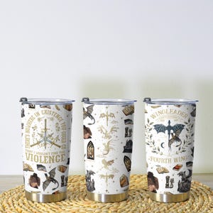 May include: Three stainless steel insulated tumblers with white backgrounds and various fantasy-themed designs. One tumbler features text that reads "THERE'S NOWHERE IN EXISTENCE YOU COULD GO THAT I WOULDN'T FIND YOU, VIOLENCE." The other two tumblers have dragon and book illustrations.
