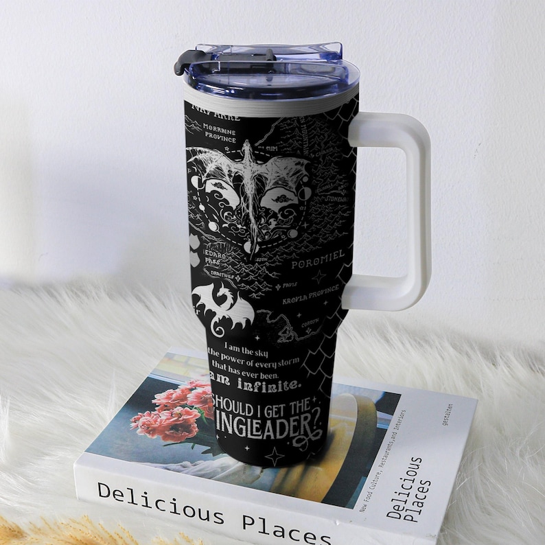 May include: Black travel mug with a white handle and lid. The mug features a map design with dragons and text that reads "SHOULD I GET THE INGLEADER?" and "I am the sky...Am infinite."