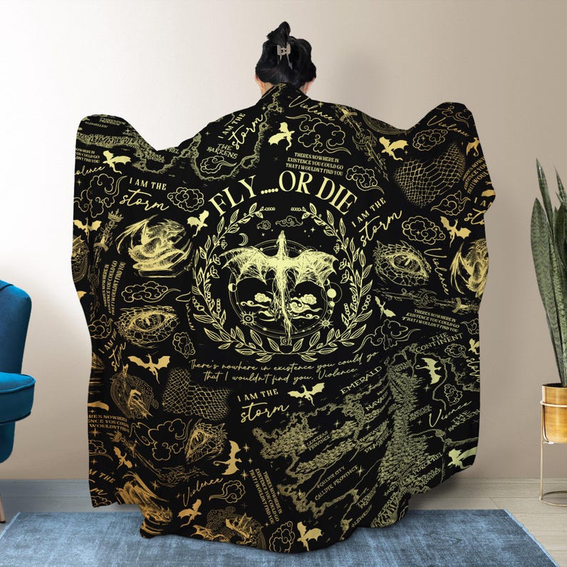 May include: Black hooded blanket with gold dragon and text design. The blanket features a central dragon illustration with the words "FLY...OR DIE" and "I AM THE STORM". Additional text and dragon graphics are scattered across the blanket.