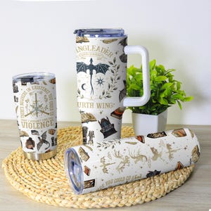 May include: A collection of insulated tumblers with fantasy-themed designs. One tumbler features the text "THERE'S NOWHERE IN EXISTENCE YOU COULD GO THAT I WOULDN'T FIND YOU VIOLENCE". Another has a dragon and the text "INGLEADER FOURTH WING". The third has dragons and the text "AGE YOU COULD GO".