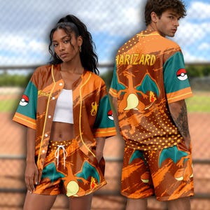 May include: A short-sleeved button-down baseball jersey and matching shorts set featuring an orange and teal Charizard graphic print, yellow polka dots, and Poké Ball icons. The back of the jersey displays the text CHARIZARD in yellow letters.