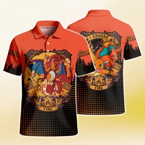 May include: An orange polo shirt featuring a graphic print of the character Charizard and a handheld gaming console. The design includes the text "I CHOOSE" and "FIRE" with a black dotted gradient pattern at the bottom and short sleeves.
