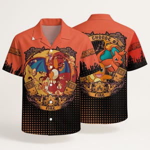 May include: An orange short-sleeve button-down shirt featuring a graphic print of Charizard and Charmander. The design includes the text "CHOOSE" and "FIRE" with stylized handheld gaming consoles, set against a black dotted gradient background.