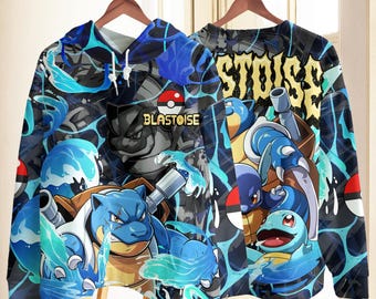 May include: A long-sleeve hooded sweatshirt featuring a vibrant all-over print of the character Blastoise and Squirtle surrounded by blue water splashes and Poké Balls. The text BLASTOISE is printed on the front and back in yellow letters.