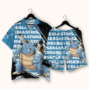 May include: A short-sleeve button-down shirt and matching shorts set in light blue, featuring a repeating Blastoise character graphic, black brushstroke accents, and the text "BLASTOISE" printed in white across the fabric on both garments.