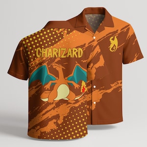 May include: A short-sleeve button-down shirt in brown and orange with a graphic of the character Charizard, the text "CHARIZARD", and a yellow dragon silhouette. The design features a pattern of yellow dots and abstract orange brush strokes.