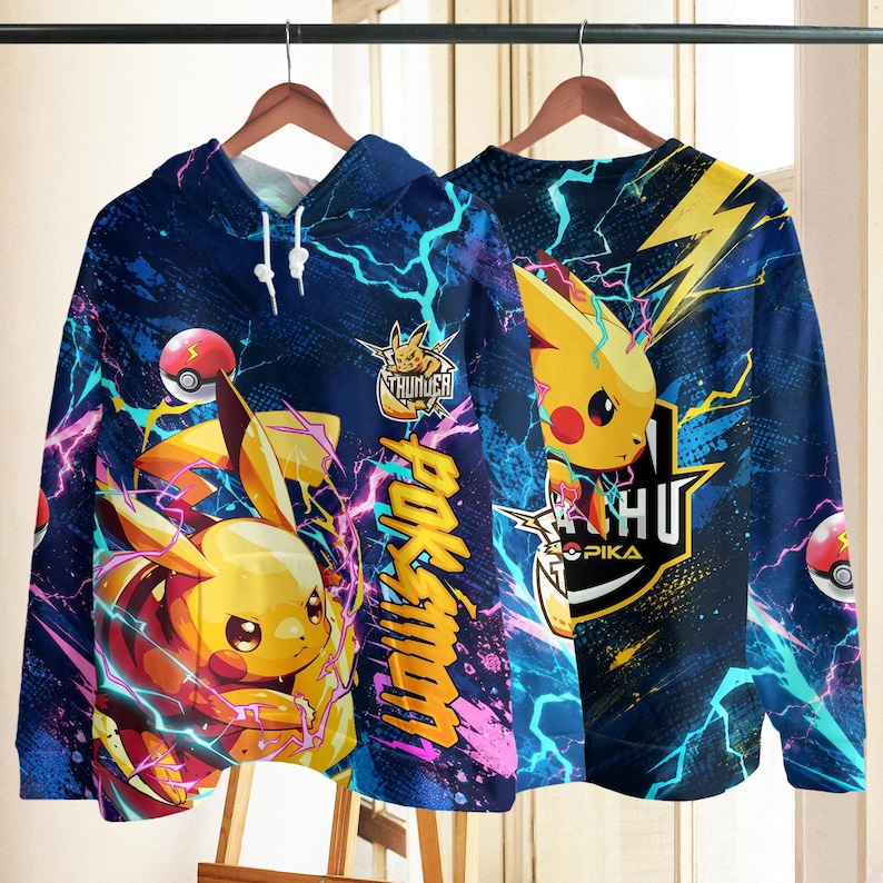 May include: A blue hooded sweatshirt featuring a yellow Pikachu character, lightning bolts, and red and white Pok&eacute; Balls. The design includes the text "POKEMON" in yellow, "THUNDER" with a Pikachu icon, and "PIKA" in white on a dark blue background.
