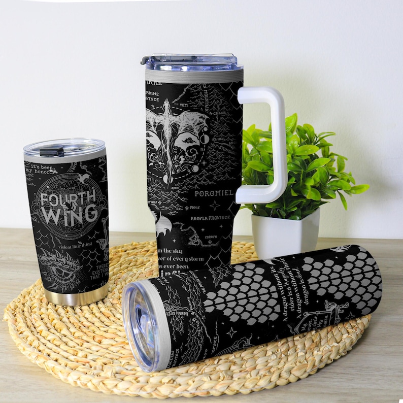 May include: Three black insulated tumblers with white graphic designs and text. One tumbler reads "FOURTH WING" with dragon illustrations. Another features a map design with the text "POROMIEL". The third has a scale pattern.