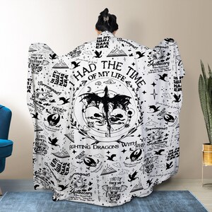 May include: A white hooded blanket featuring a black dragon design with the text "I had the time of my life fighting dragons with you." The blanket has a repeating pattern of stars, apothecary bottles, and other graphics.