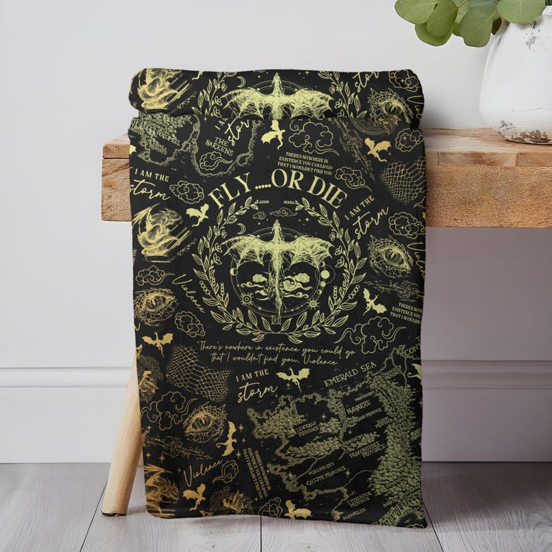 May include: Black blanket with a gold dragon and map design. The blanket features the text "FLY...OR DIE" and "I AM THE STORM". The design includes dragons, clouds, and a map, creating a fantasy theme.