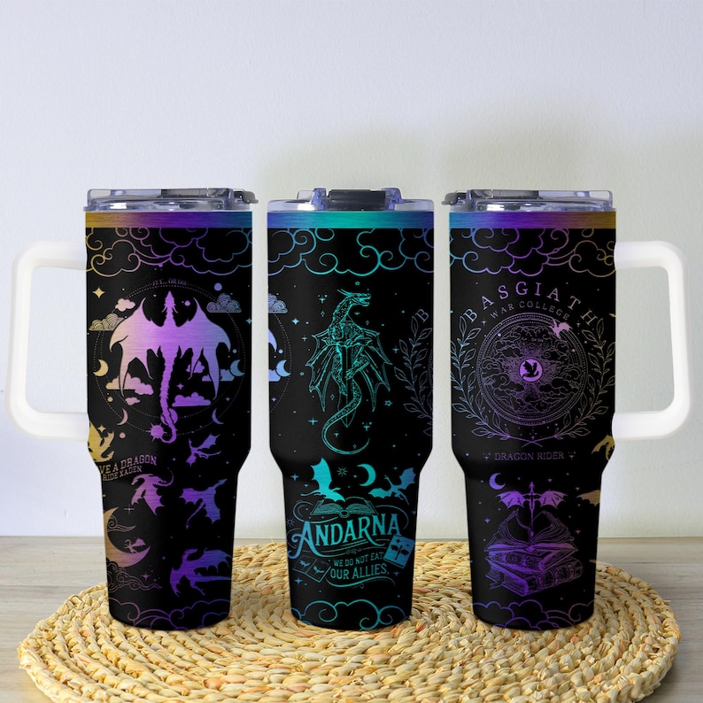 May include: Three black insulated tumblers with white handles and lids. Each tumbler features a dragon design in shades of purple, teal, and gold. Text includes "KEA DRAGON", "ANDARNA", and "BASGIATH WAR COLLEGE".