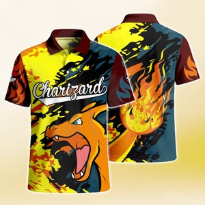 May include: A short-sleeve polo shirt featuring a vibrant graphic print of the character Charizard with flames in yellow, orange, and dark blue. The shirt has a dark maroon collar and button placket, with the text Charizard printed in white script.