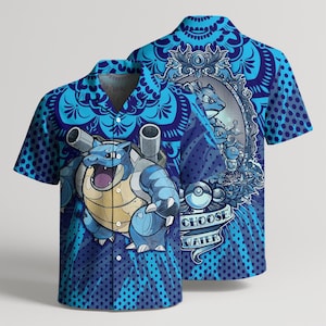 May include: A short-sleeved button-down shirt in shades of blue featuring a large graphic of a blue turtle-like creature with cannons on its back. The design includes a circular frame with smaller creatures, a sphere, and the text CHOOSE WATER.