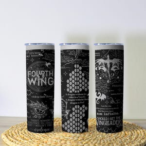 May include: Three black and white insulated tumblers with fantasy-themed designs. Each tumbler features text and illustrations, including dragons and maps. The text includes phrases like "Fourth Wing" and "Should I get the Wingleader?"
