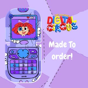Puede incluir: Ilustración de dibujos animados de un teléfono plegable morado con un personaje en la pantalla. El teléfono tiene un teclado con números y símbolos. El texto "THE AMAZING DIGITAL CIRCUS" está encima del teléfono y "Made To order!" debajo.