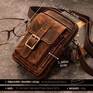 May include: A brown leather crossbody bag with a buckle and a zip. The bag measures 13cm long, 5cm wide, and 19cm high. It has an adjustable shoulder strap and weighs 280g.
