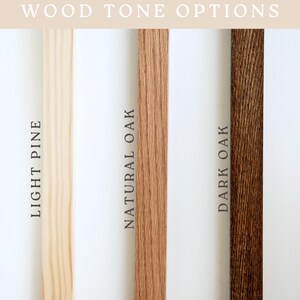 May include: Image showcasing three wood tone options: Light Pine, Natural Oak, and Dark Oak. The text "WOOD TONE OPTIONS" is displayed at the top. Each wood sample is a vertical strip, with the names of the wood types printed vertically.