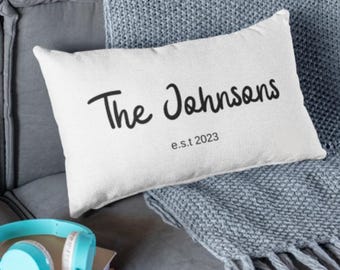 Może przedstawiać: Biała prostokątna poduszka z czarnym tekstem, który brzmi "The Johnsons est. 2023".