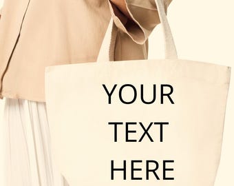 May include: A white canvas tote bag with black text that reads "YOUR TEXT HERE".