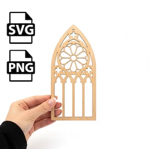 May include: A light-colored wooden cutout in the shape of a cathedral window, held by a hand. The window design features a central circular pattern and arched top. Two black and white file icons, labeled "SVG" and "PNG", are in the upper left.