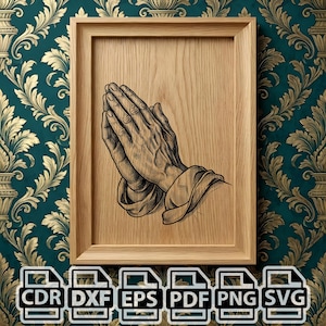 May include: A framed wooden art print featuring a detailed black and white illustration of clasped hands in prayer. The artwork is set against a light wood grain background within a natural wood frame. The image is surrounded by a teal and gold floral wallpaper.