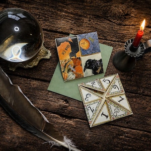 May include: A paper fortune teller with numbers one through eight, a square card featuring illustrations of a black cat, moon, pumpkin, and raven, a clear crystal ball on a gold stand, a red candle in a black holder, and a dark feather quill.