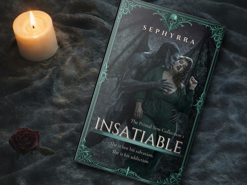 Paperback book titled Insatiable by Sephyrra resting on dark fabric with a lit candle and red rose beside it in a moody gothic setting.