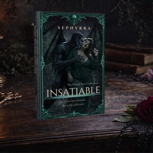 Insatiable alternate cover paperback standing upright on a wooden table with antique key, candlelight, and red rose in a gothic styled scene.