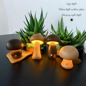 May include: Four mushroom-shaped night lights with a warm glow. The lamps have wooden stems and caps in shades of brown. The text in the image reads "Soft light, Warm light without glare, Sleeping night light."